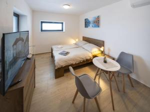 a bedroom with a bed and a tv and a table at Studio V Šachu by Interhome in Dačice