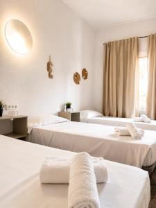 a room with three beds with towels on them at Malvarrosa Beach Rooms in Valencia