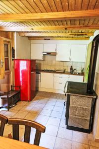 a kitchen with a red refrigerator and a table at Chalet Le Châtelaret by Interhome in Finhaut