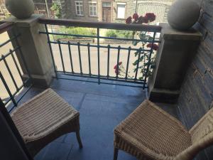 two chairs and a balcony with a view of a street at Bed & Breakfast - Haus Hubertus in Brauneberg