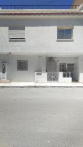 an empty street in front of a white building at Maison Lyne in Hammamet
