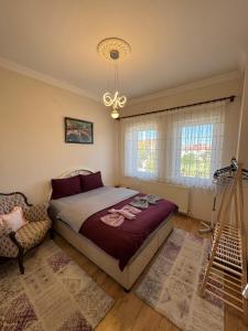 a bedroom with a bed and a chair and a chandelier at Kapadokya Denizhan Villa in Ürgüp
