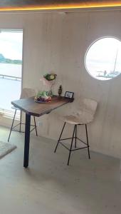 a table and a chair in a room with a window at Unique floating retreat Sleeps 4 in Sölvesborg