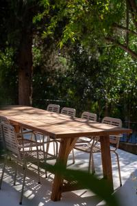 a wooden table with four chairs around it at Büyükada Apart Hotel in Adalar