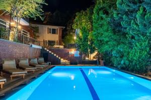 a swimming pool at night with chairs around it at Büyükada Apart Hotel in Adalar