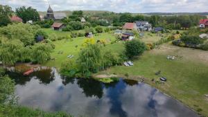 an aerial view of a small village with a pond at Domki nad rzeką Ełk in Prostki