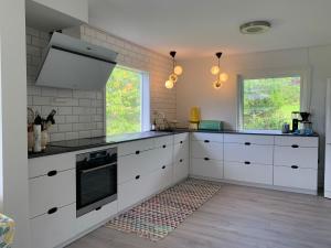 a kitchen with white cabinets and a stove at Lyngtun in Ørskog
