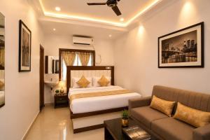 a hotel room with a bed and a couch at Golden Palace in Kolkata +22 photos