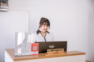 a woman standing behind a desk with a laptop at May Bliss Villa in Danang +50 photos