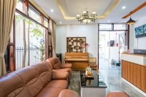 a living room with a couch and a piano at May Bliss Villa in Danang