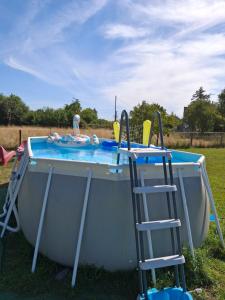 a pool with two chairs and a table with a life raft at Les châtillonnes 25 minutes du zoo de beauval in Châtillon-sur-Indre