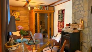 a living room with a glass table and a fireplace at Bakancsos Kulcsosház in Dobogókő
