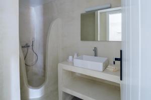 a white bathroom with a sink and a shower at GM Canava1916 in Megalochori +18 photos