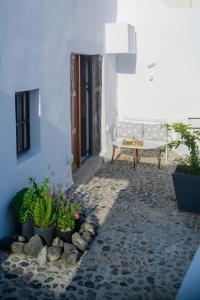a courtyard with a bench and potted plants at GM Canava1916 in Megalochori