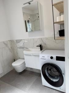 a bathroom with a washing machine and a sink at Zbilje Lakeside Apartment in Medvode +120 photos