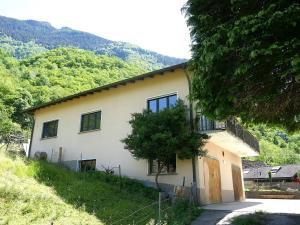 a house with a tree in front of a mountain at Apartment Casa Malva by Interhome in Malvaglia