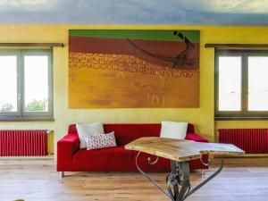 a living room with a red couch and a painting at Apartment Casa Malva by Interhome in Malvaglia +39 photos