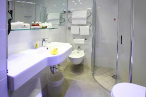 a bathroom with a sink and a shower and a toilet at Hotel Berna in Milan