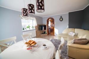 Dom Bory Tucholskie في Gostycyn: غرفة معيشة مع طاولة بيضاء وأريكة