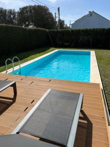 a swimming pool in a yard with a wooden deck at Aljezur Houses 3 bedrooms 2 bathrooms with Condo Pool in Aljezur