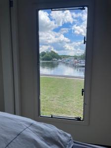 a bedroom window with a view of a river at TinyHouse am Stadthafen in Hennigsdorf +1 photo
