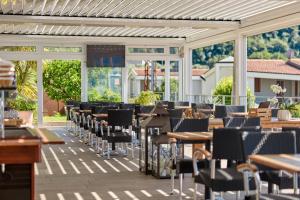 a patio with tables and chairs and windows at Hotel Villa Smeralda in Malcesine