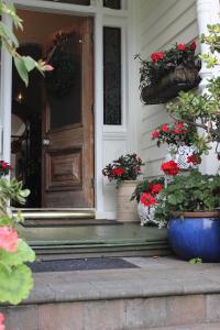 a front door with potted plants on the steps at Peace and Plenty Inn in Auckland