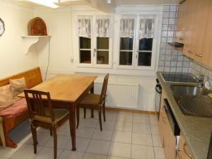 a kitchen with a table and chairs and a sink at Holiday Home by Interhome in Lungern