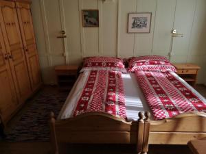 a bed with red blankets and pillows on it at Holiday Home by Interhome in Lungern