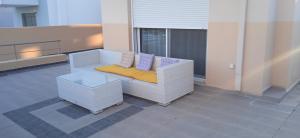 a white couch with pillows on a balcony at Villa Verona Pool in Lachania
