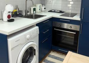 a kitchen with a washing machine and a sink at Casa na Aldeia in Melides