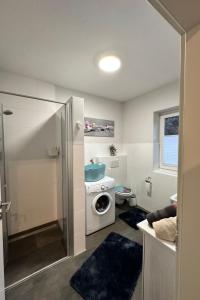 a bathroom with a washing machine and a toilet at Apartment FEWO „Am Stausee“ by Interhome in Friesoythe