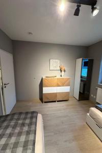 a bedroom with a bed and a dresser in a room at Apartment FEWO „Am Stausee“ by Interhome in Friesoythe
