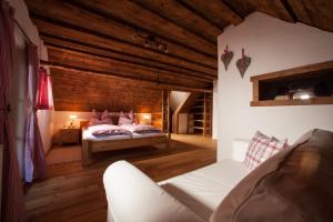 a bedroom with a bed and a couch in a room at Zehna Hube in Semriach