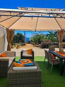 a patio with a table and chairs and an umbrella at VILLA MADRE in Marina Serra