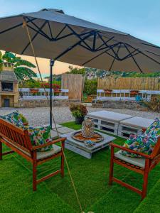 a patio with two chairs and an umbrella at VILLA MADRE in Marina Serra