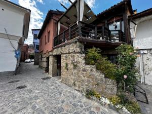 a building with a balcony on the side of it at Varosi Guesthouse in Edessa