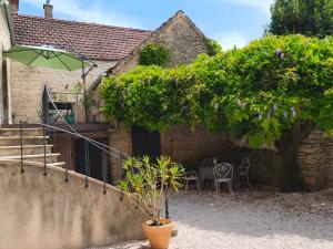 a house with a patio with an umbrella at La petite maison d'à côté in Noyers