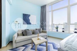 a living room with a couch and a large window at Bloomfields Studio in Hydra Avenue - Reem in Abu Dhabi +5 photos