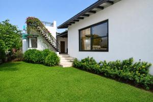 a house with a yard with grass and flowers at Nivaant Villa by StayAtlas in Igatpuri