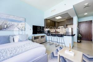 a bedroom with a king sized bed and a kitchen at Bloomfields Studio in Hydra Avenue - Reem in Abu Dhabi