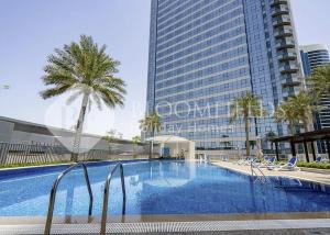 a swimming pool in front of a tall building at Bloomfields Studio in Hydra Avenue - Reem in Abu Dhabi