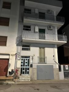 a white building with a balcony and a door at Melina House in Bernalda