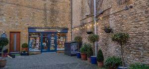 a store front of a brick building with potted plants at Cotswold Townhouse - Adults Only in Stow on the Wold