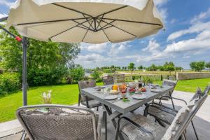 a table with an umbrella on a patio at Ferienhaus Seebrise in Loddin