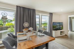 a living room with a table and chairs and a television at Ferienhaus Seebrise in Loddin
