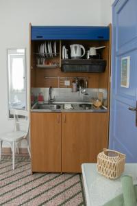 eine Küche mit Spüle und blauer Tür in der Unterkunft Aerides Studios in Methana