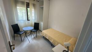 a small room with a bed and a table and chairs at VUT de uso turístico Las Palomas in Arenas de San Pedro