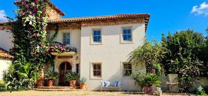 a white house with plants and flowers at Sandmartins Private Secure Villa in Simondium