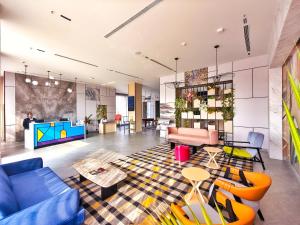 a living room with blue couches and a tv at 7 Apple Hotel Visakhapatnam in Visakhapatnam
